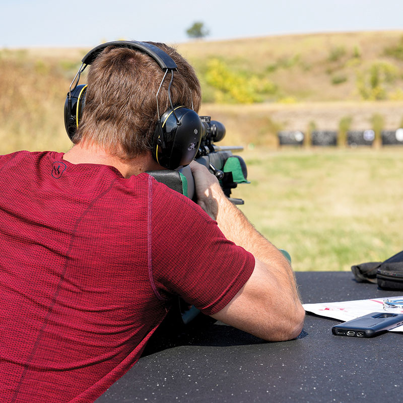 Person firing rifle at a range