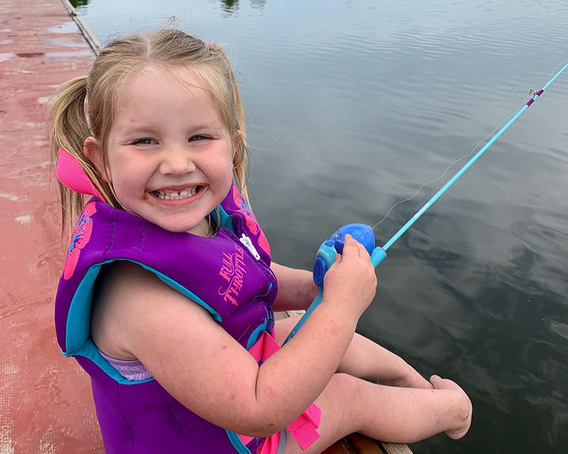 Little girl fishing from a pier