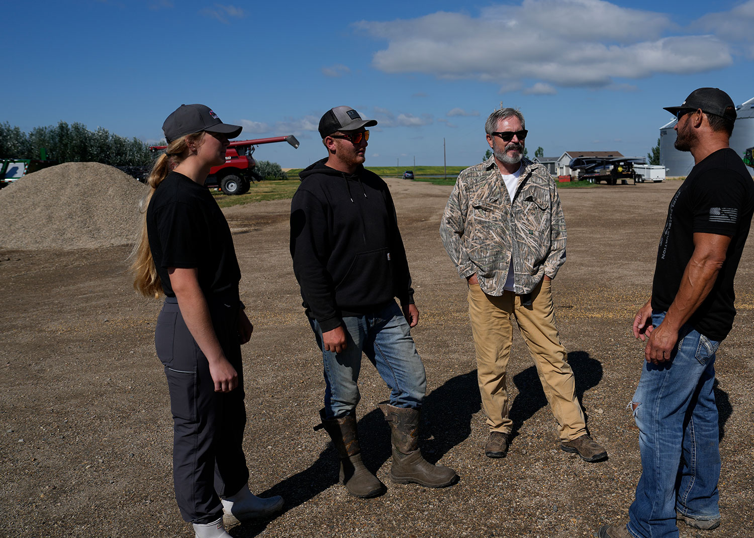 Farmer and hunters talking in a farm lot