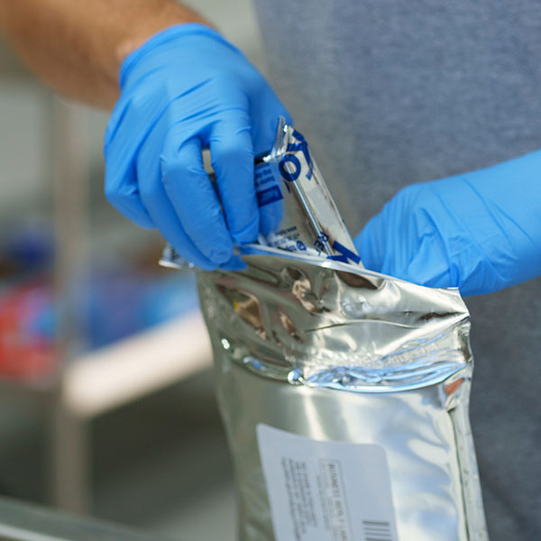 Person placing icepack into insulated mailer