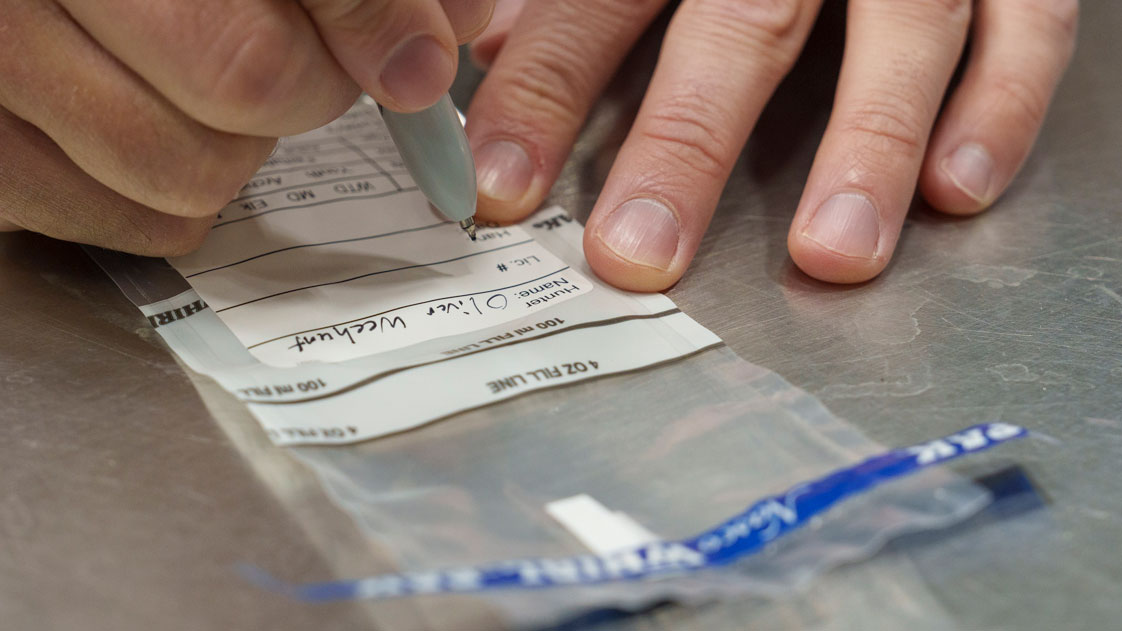 Person filling out label on whirlpack