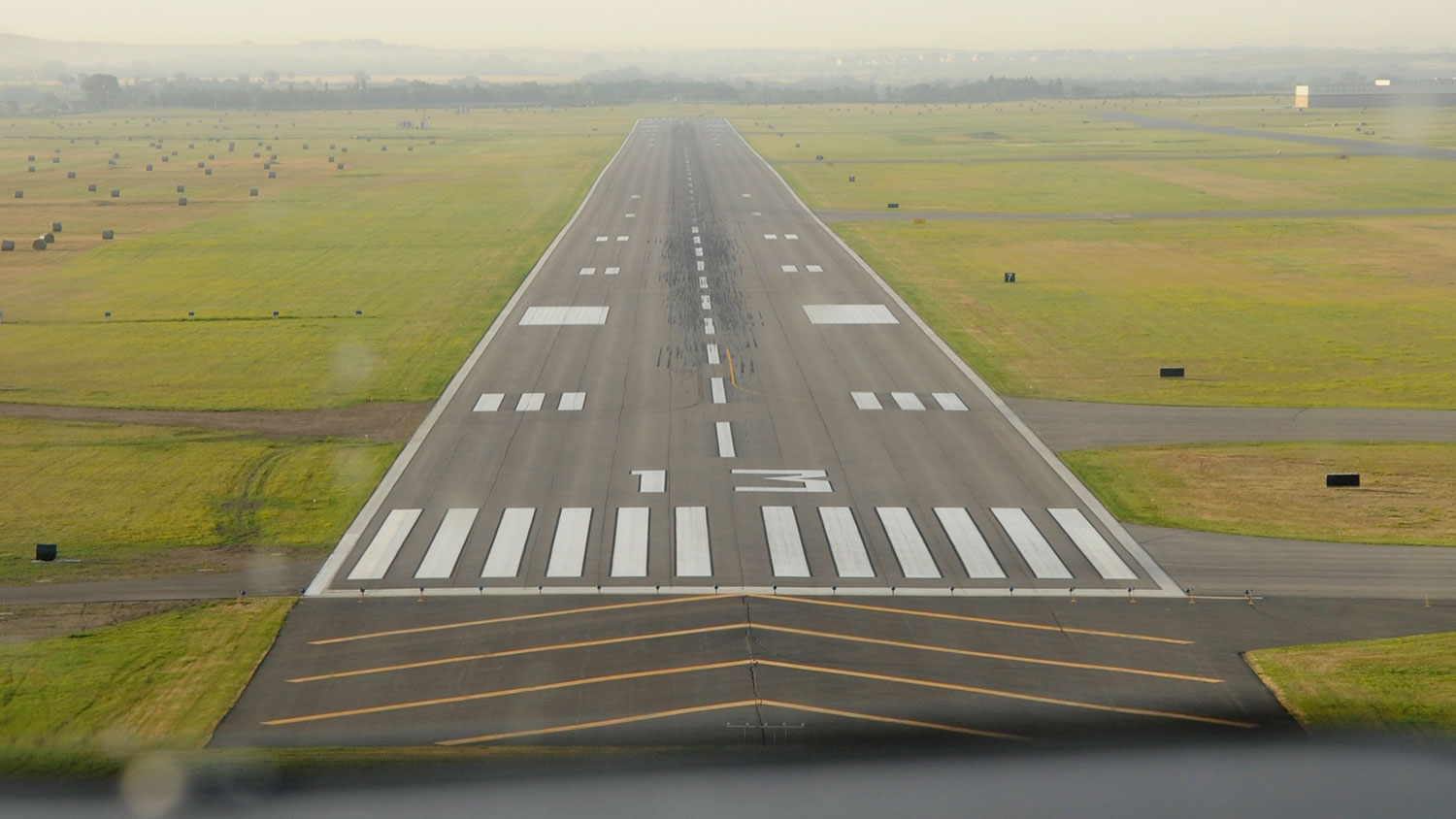 View from plane front window while approaching a runway