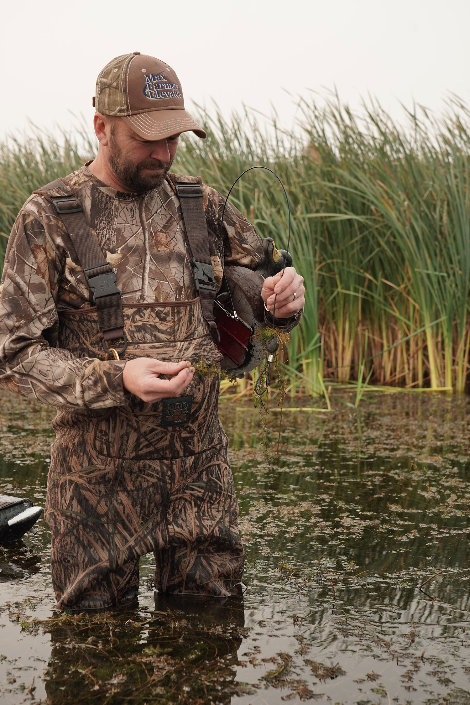 Duck hunter in waders holding decoy