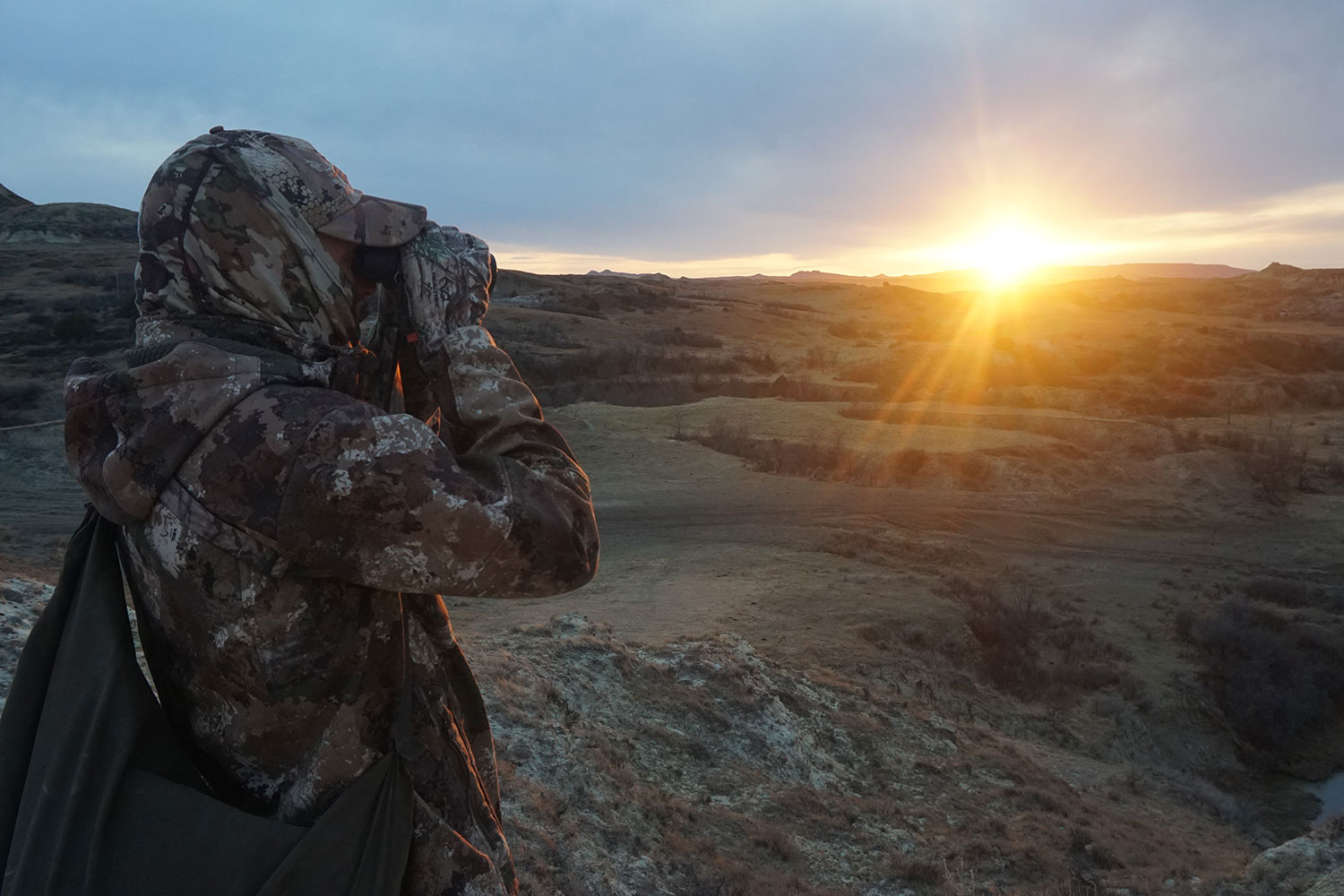 Turkey hunter using binoculars to look for turkeys