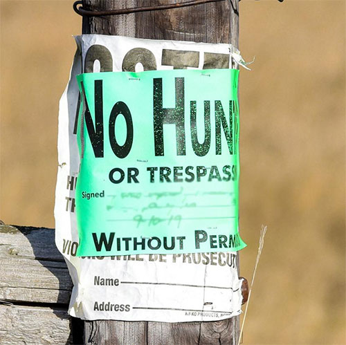 Posted sign in a green field