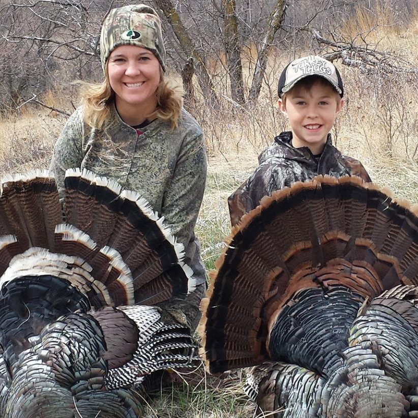 Mom and son with harvested turkeys