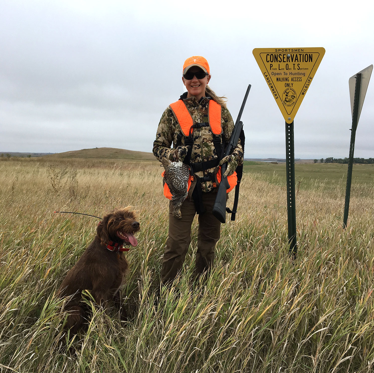 Hunter with bird dog near plots sign