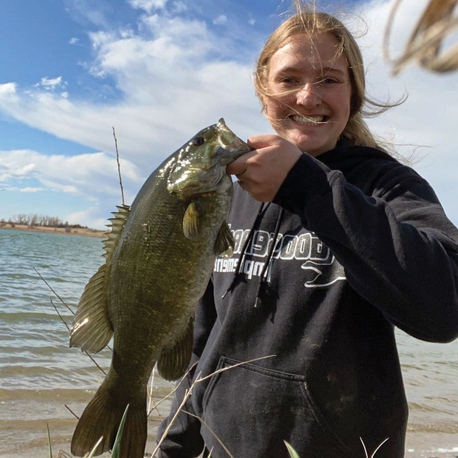 Girl holding smallmouth bass she caught shorefishing
