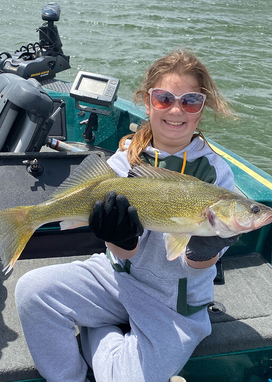 Girl in boat holding walleye she caught