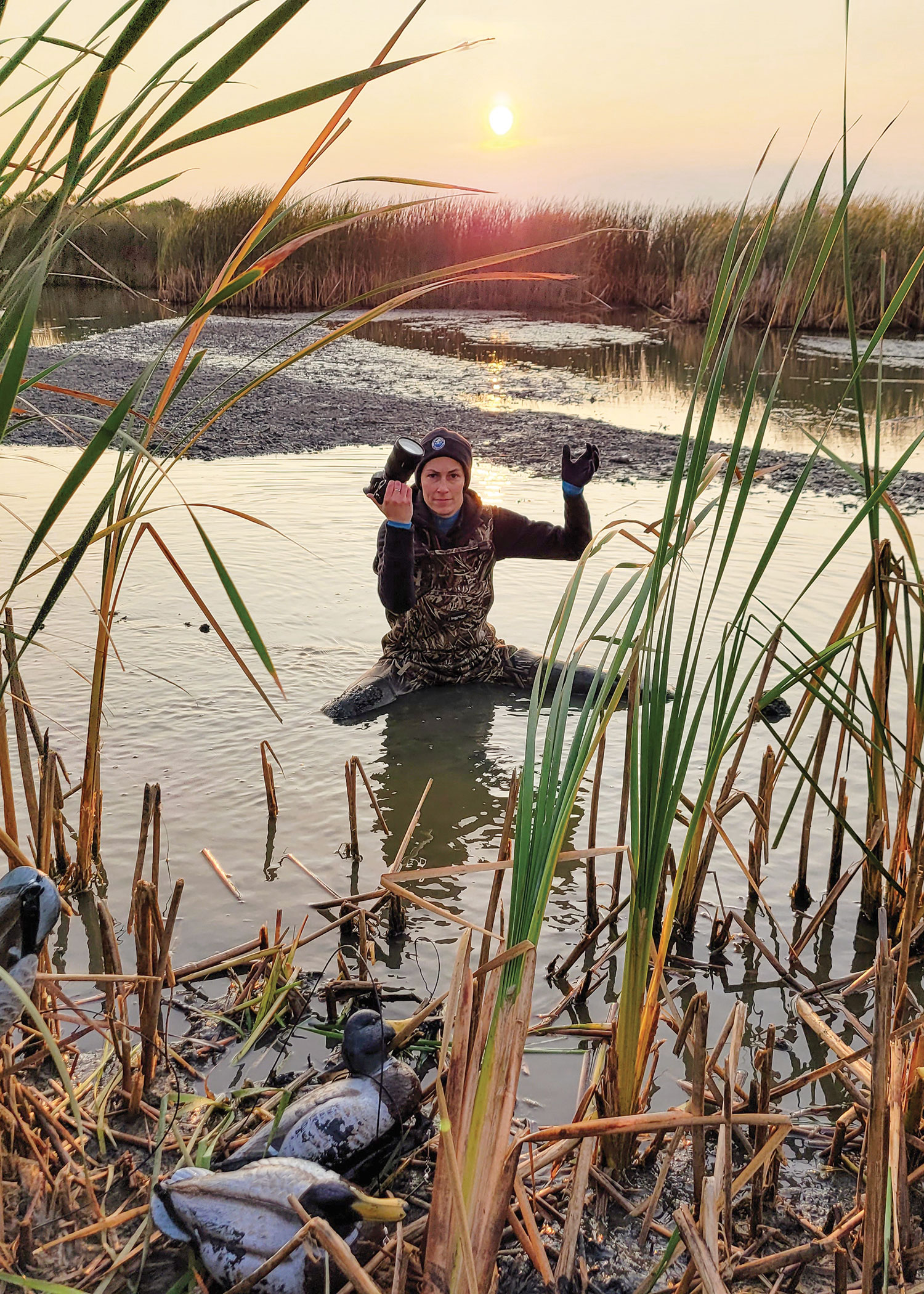 Ashley in water getting photo of youth duck hunter