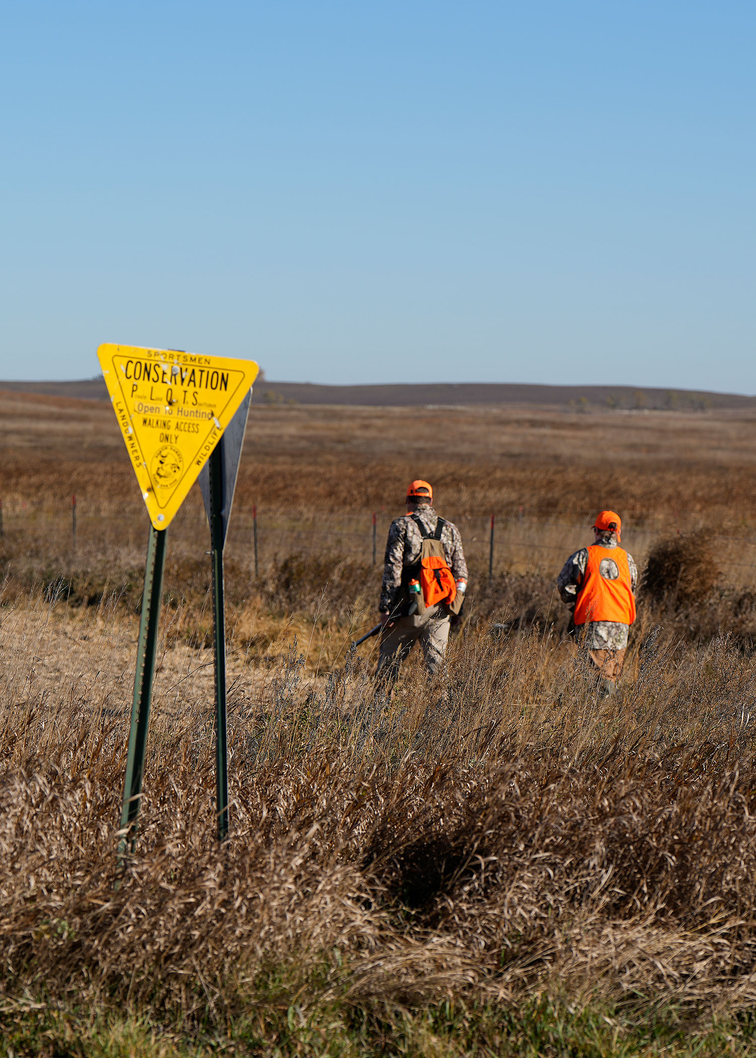 Hunters walking behind plots sign