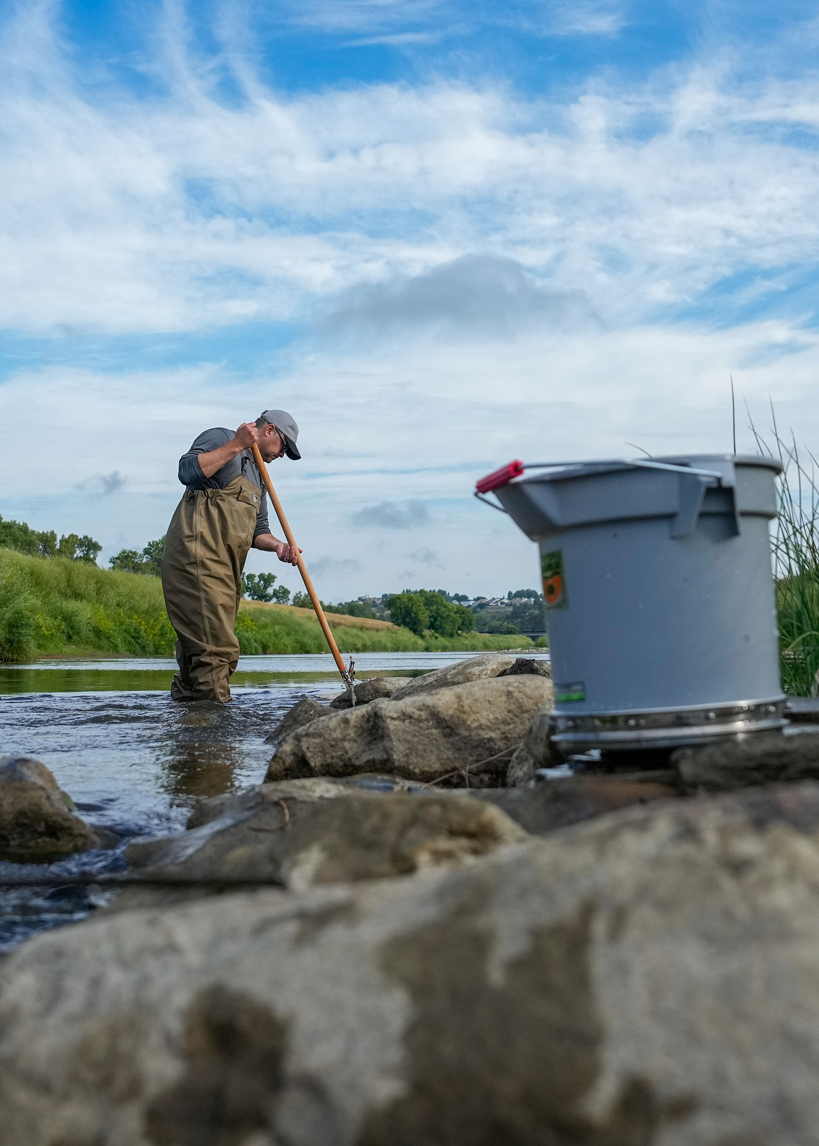 Aaron Larsen searches for aquatic invertebrates in the Heart River.