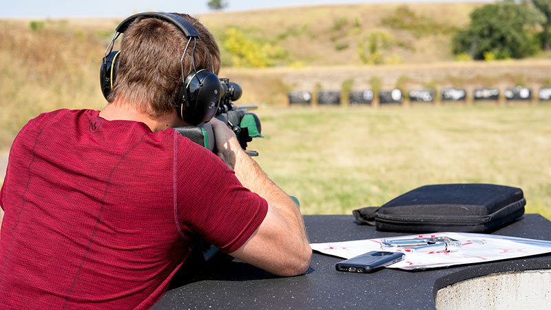 Person firing rifle at a range