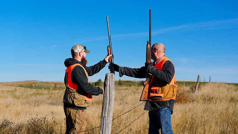 Hunters crossing a fence