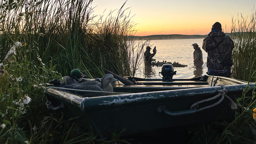 Duck hunters with decoy and boat
