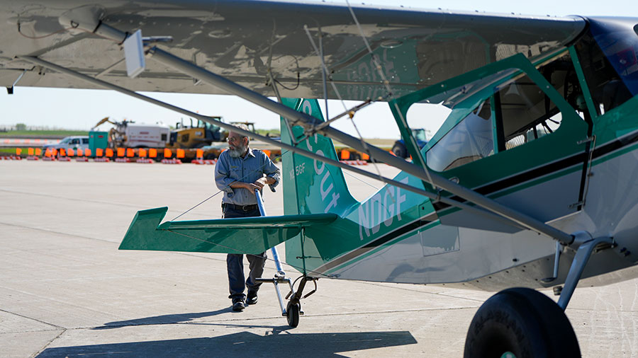 Pilot pulling plane out of hanger