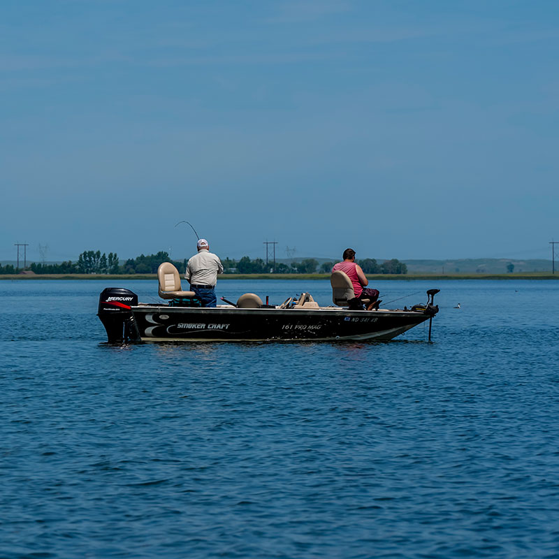 Two people fishing from a boat on a lake