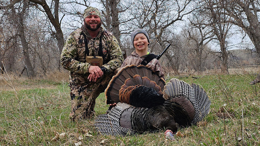 Man and boy with turkey boy harvested