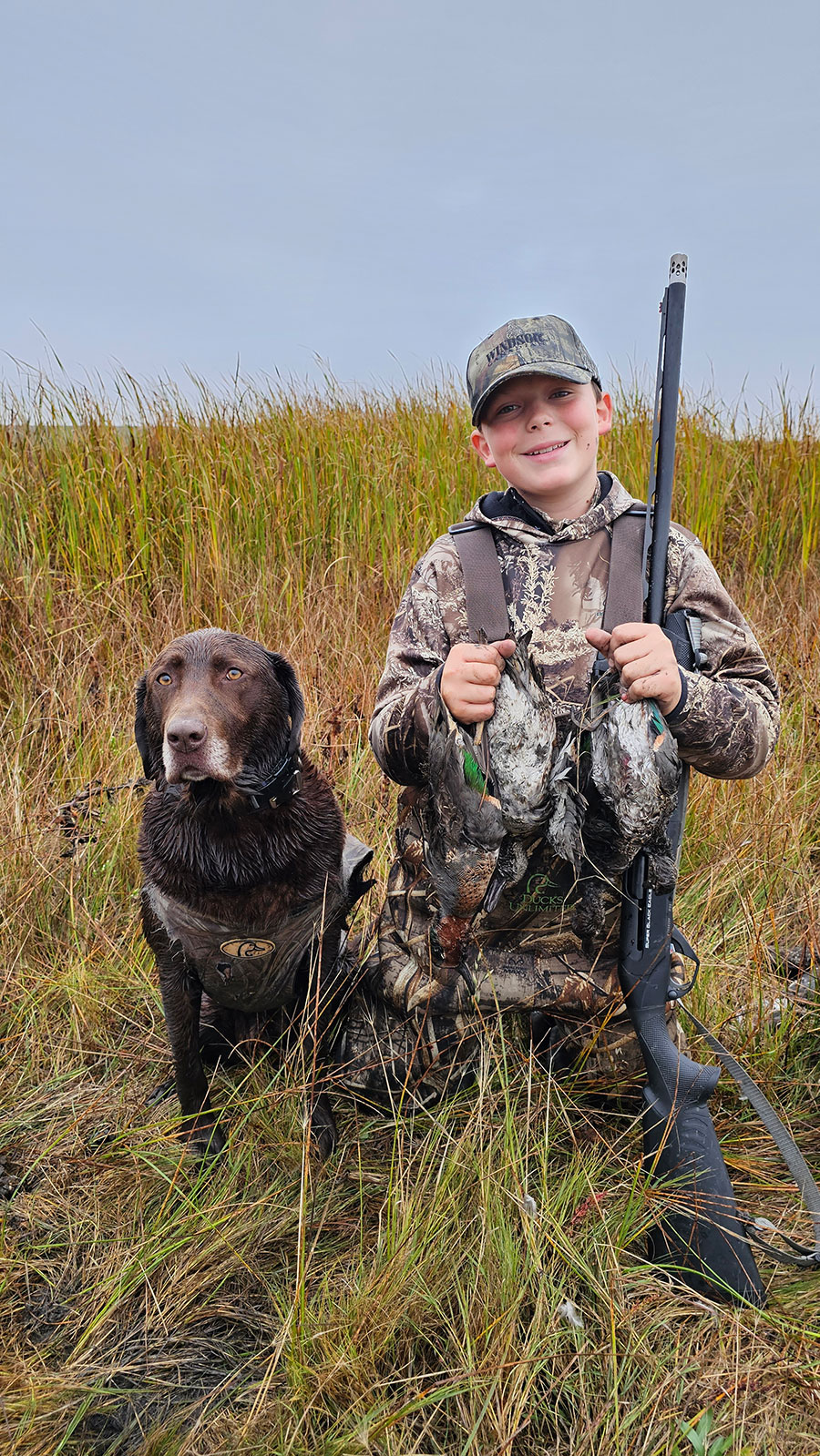 Boy with dog and ducks they harvested