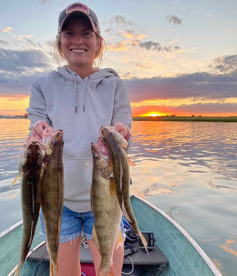 Calyl at sunset on boat with4 fish she caught