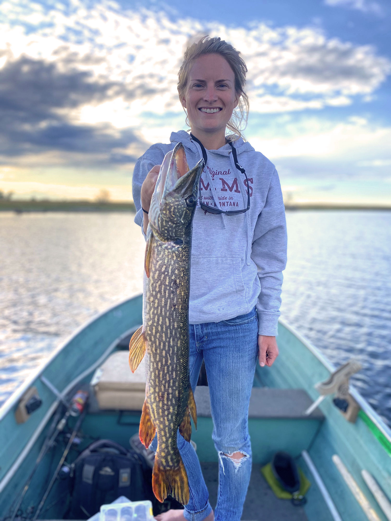 Cayla holding pike in boat