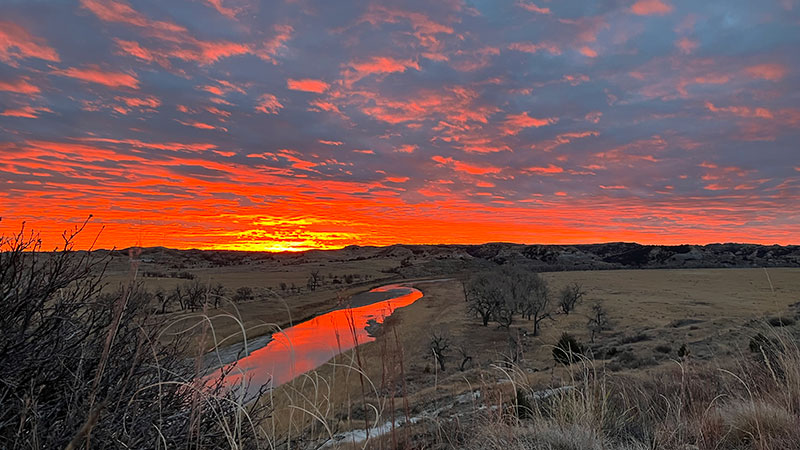 Sunset over a river in the badlands