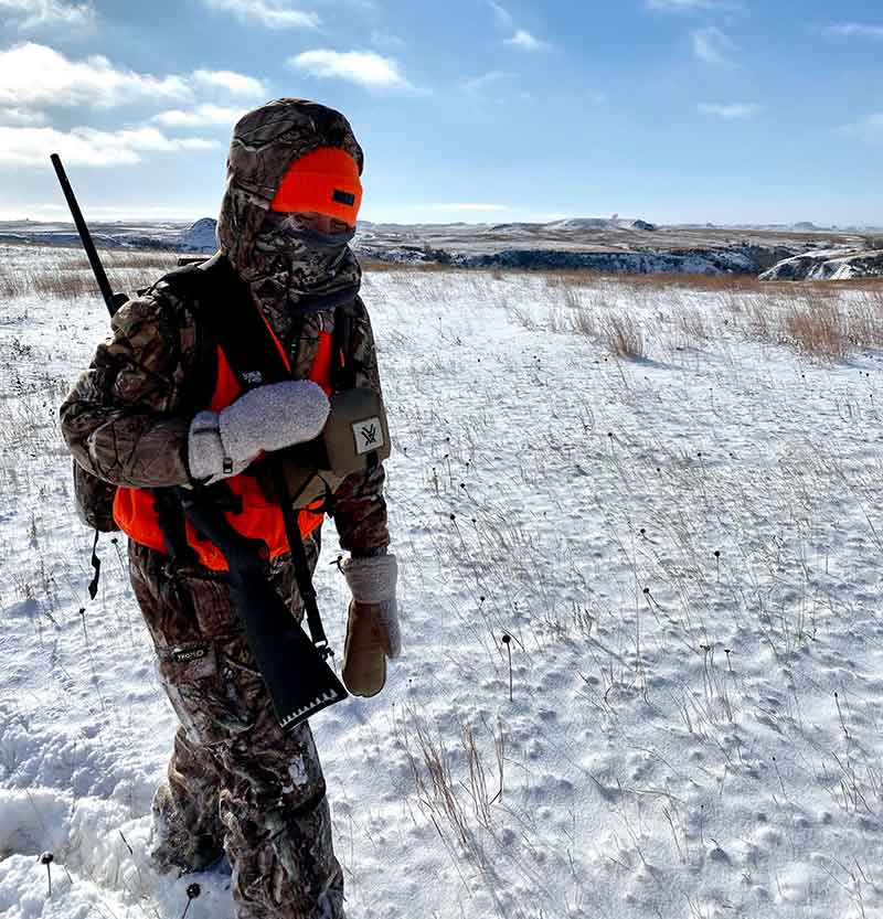 Hunter walking on plains in snow