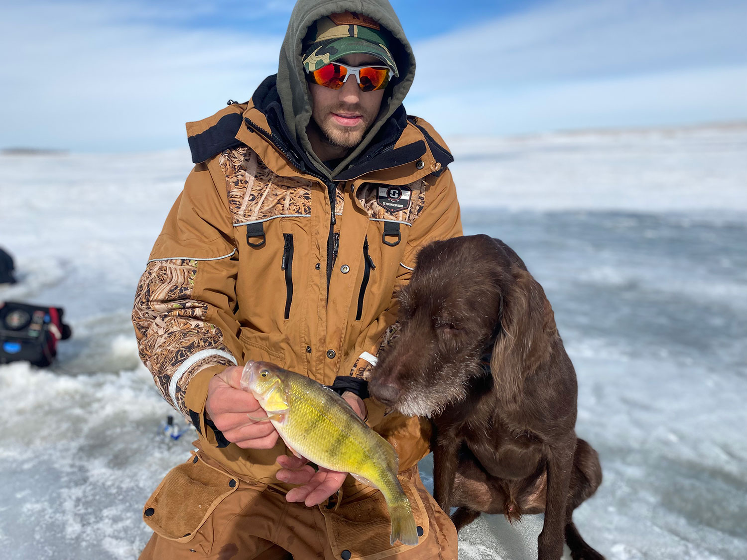 Scott holding a perch with dog Finley looking at it like it might be dinner