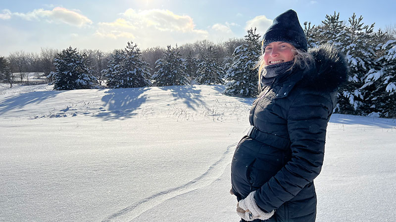 Cayla in the snow showing off the baby bump