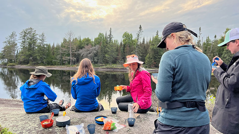 Author with group of friends on river shoreline