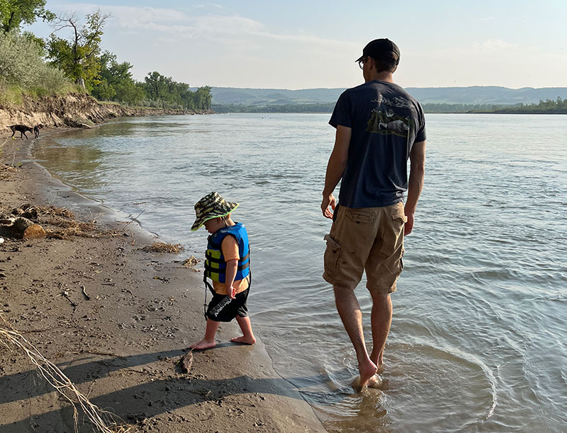 Man and son walking on lake beach