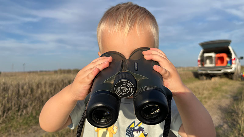 Fisch looking through binoculars backwards