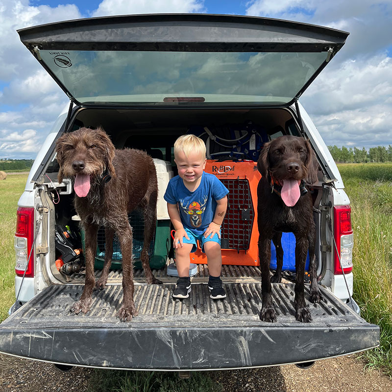Rhett with Finns and Fischer on a truck tailgate