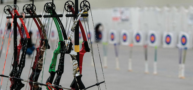 NASP bows hanging from rack with targets setup in background