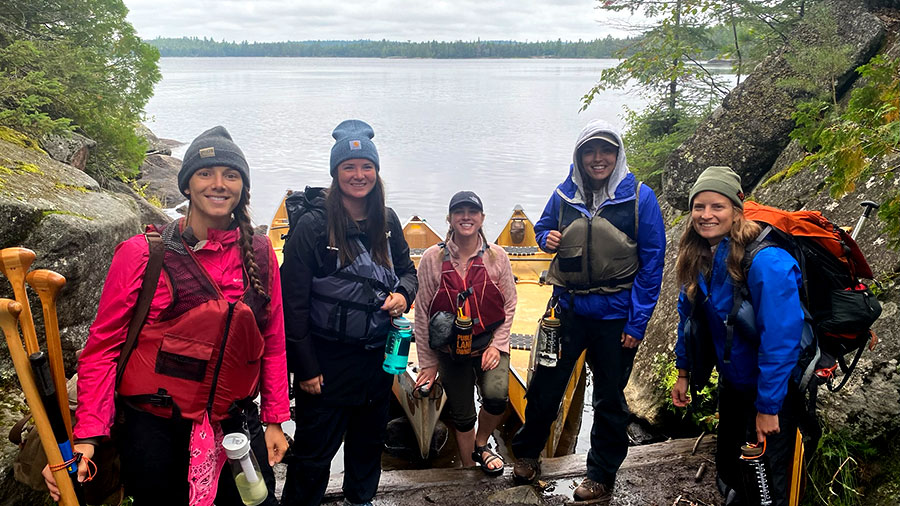 Group of women with canoes by river