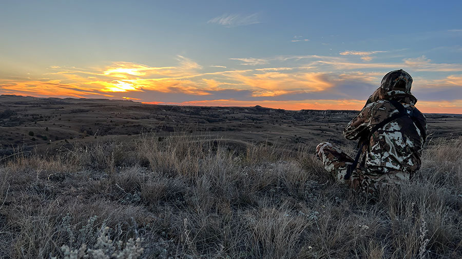 Person in badlands hunting at sunrise