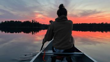 Woman canoeing at sunset