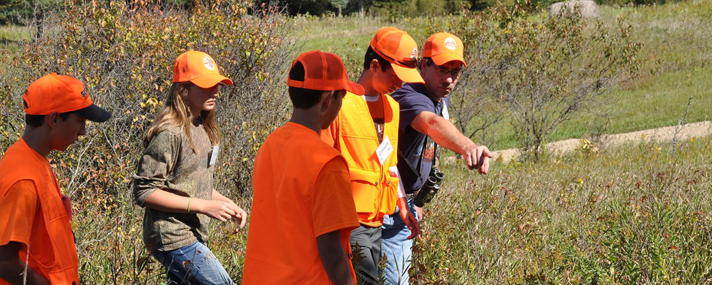 Kids in field learning to hunt