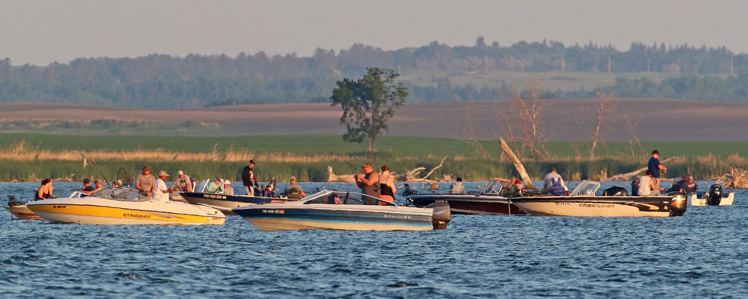 Boats on lake with people fishing