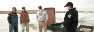 Game warden talking with ice anglers