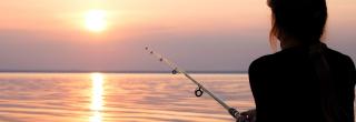 Woman fishing at sunset