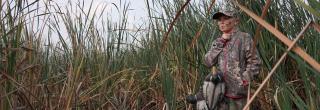 Young girl carrying duck decoys to set for her hunt