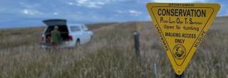 Hunter by truck behind PLOTS sign