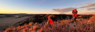 Hunters on a prairie hill looking for deer