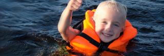 Kid wearing a life jacket in the water
