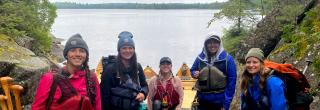 Group of women with canoes by river
