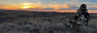 Person in badlands hunting at sunrise