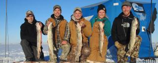 Group of ice anglers posing with fish they caught