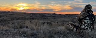 Person in badlands hunting at sunrise