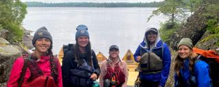Group of women with canoes by river